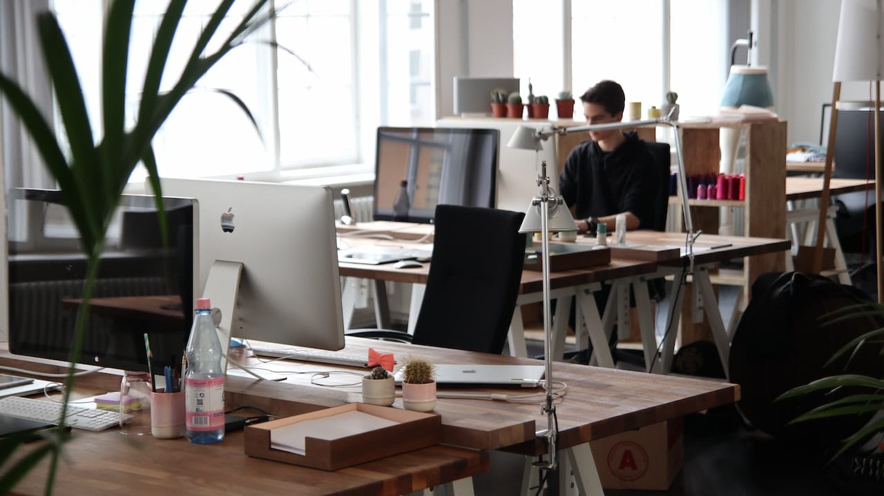 man sitting at a desk in an open-concept workplace