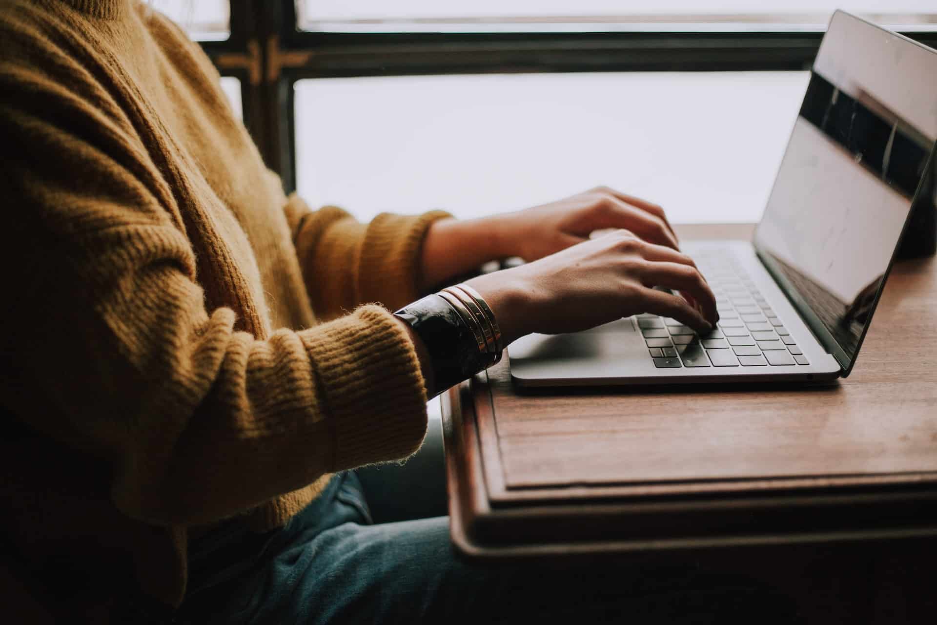 person sitting and typing on laptop