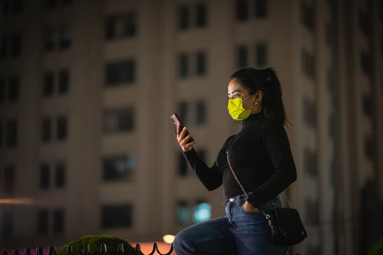 woman in a mask looking at phone
