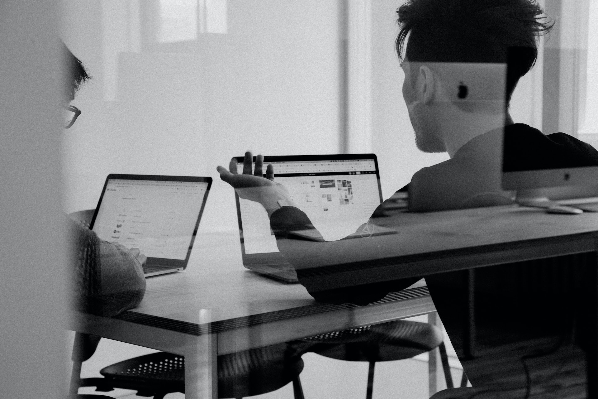 man using macbook pro in a boardroom