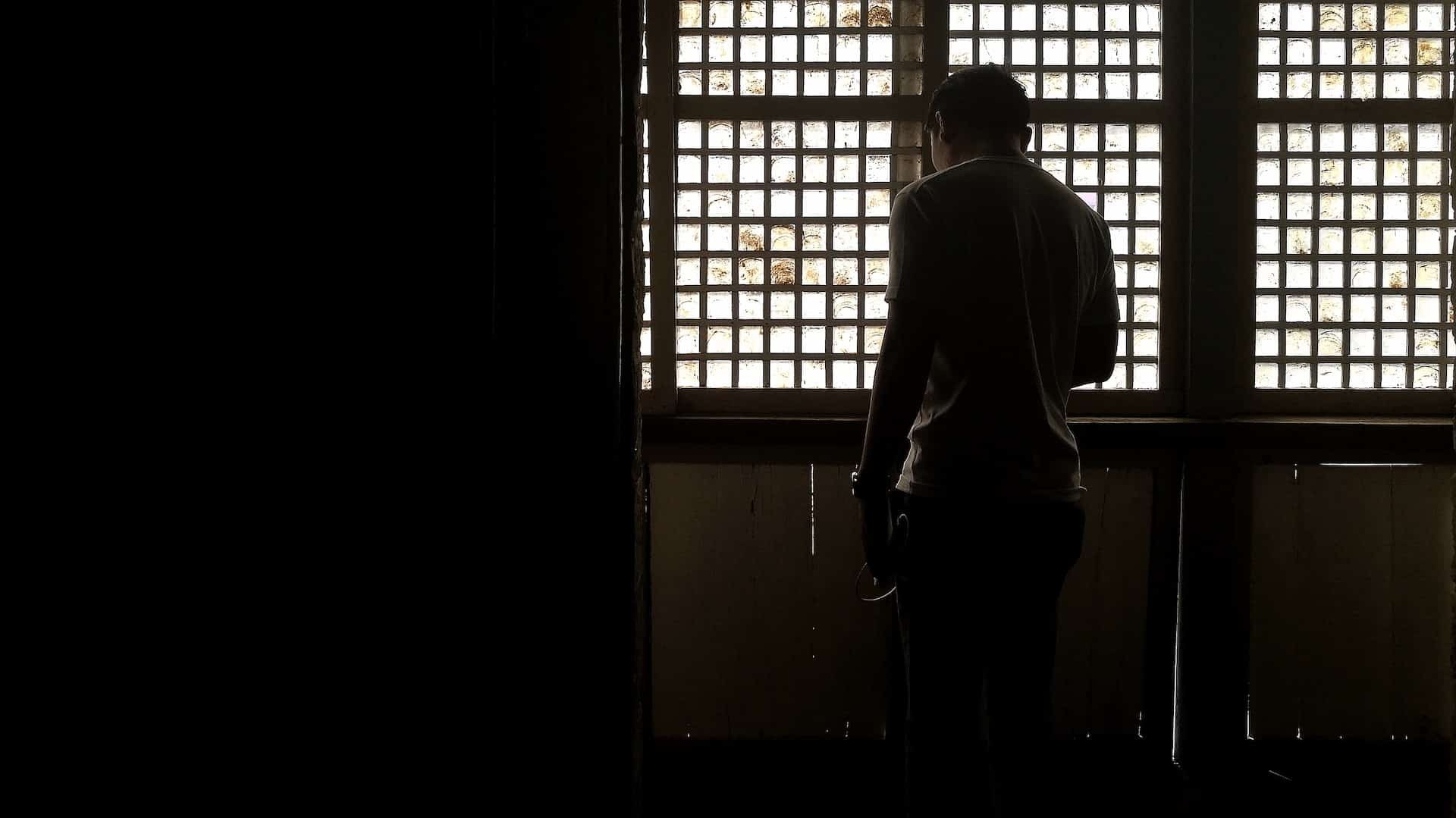 Philippines Man Standing Near Caged Window