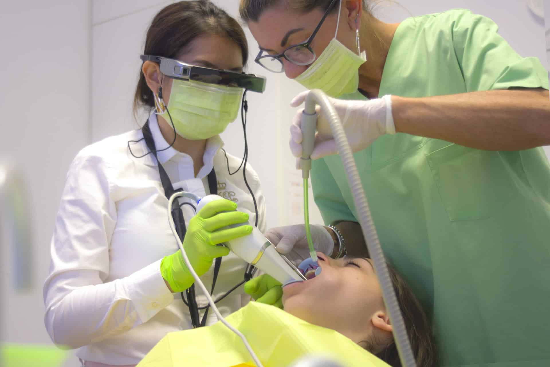 two people in scrubs performing dentistry