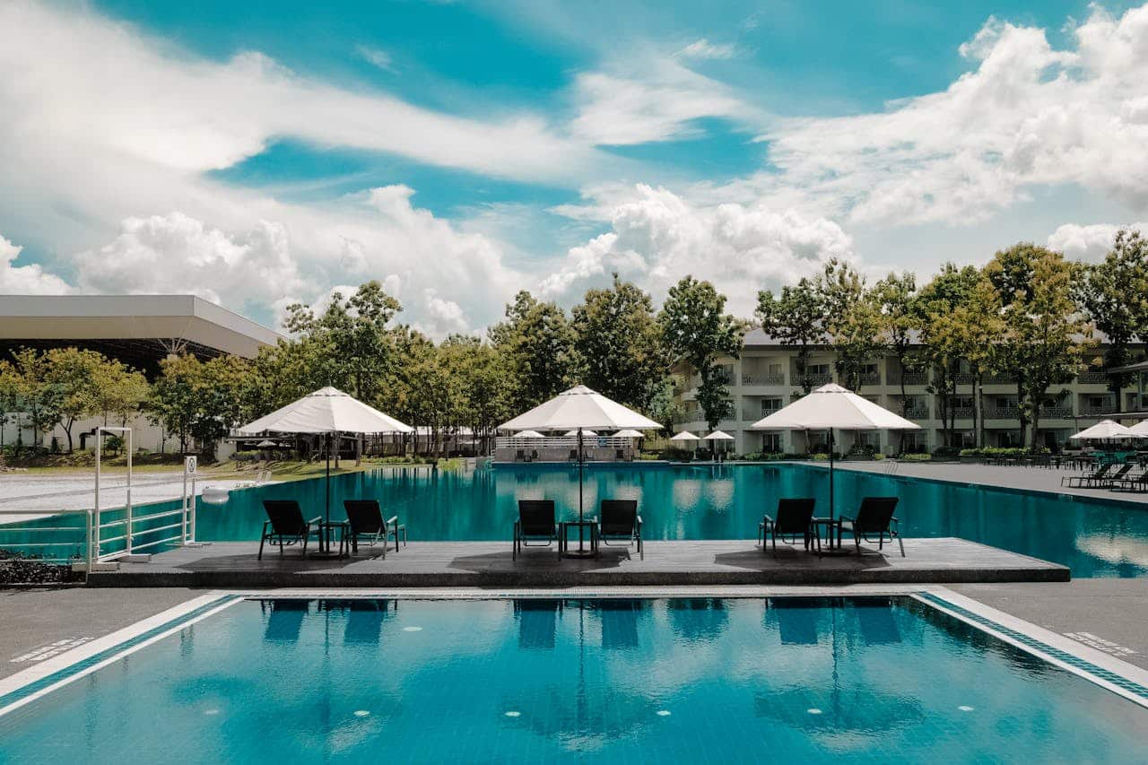 outdoor lounge chairs and umbrellas by a pool