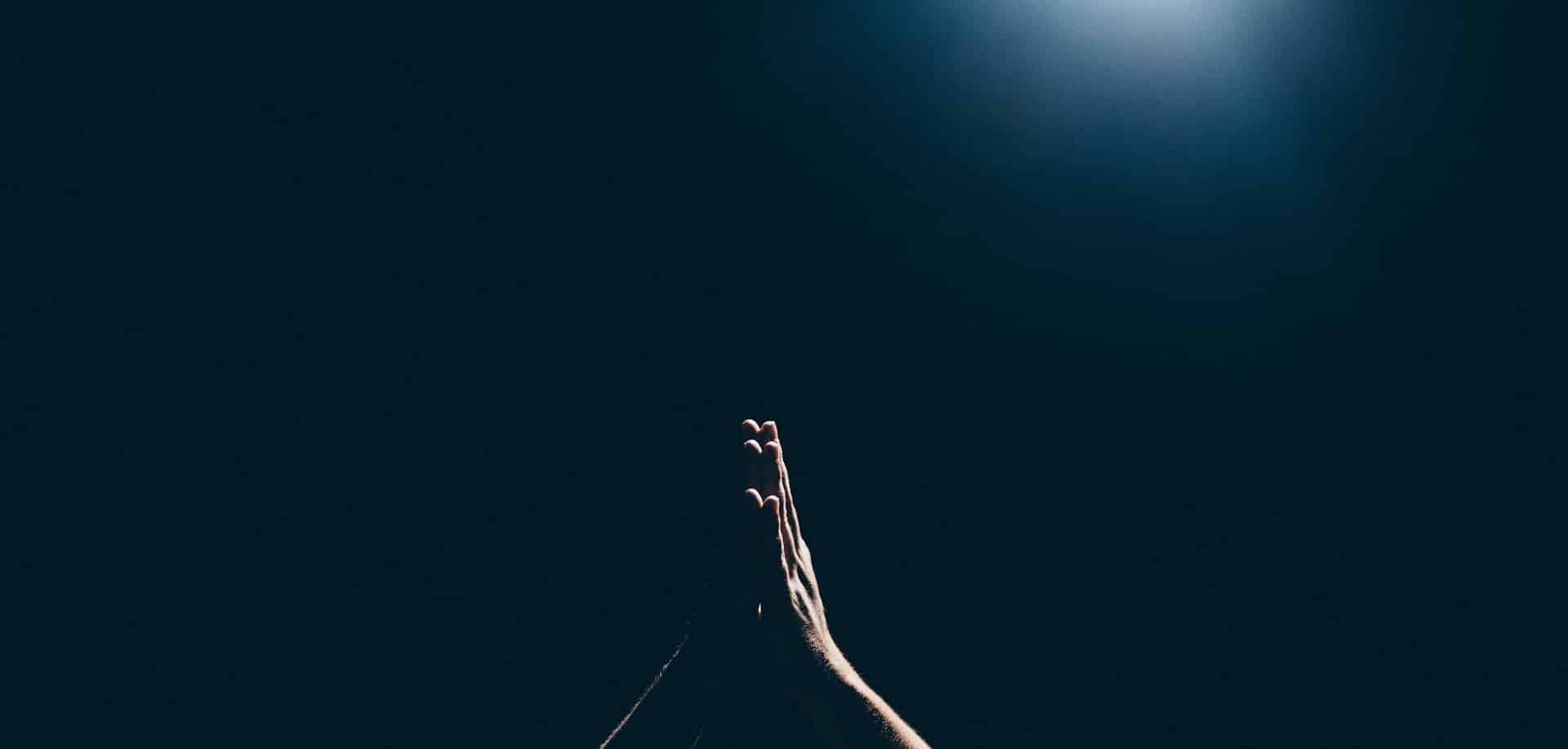 a person raising arms and hands clasped together