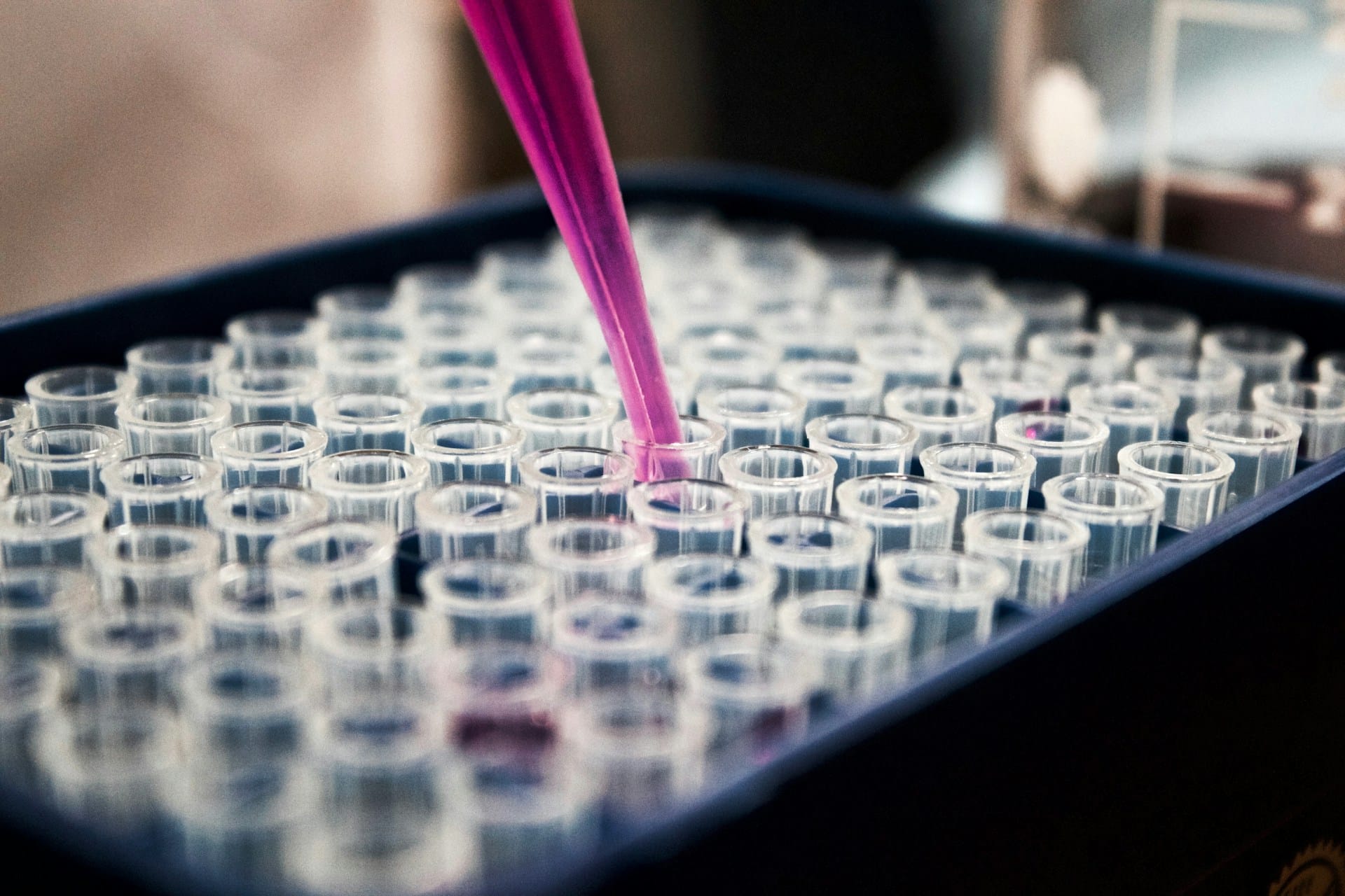 Close-up of a pipette dropping fluid into test tubes, representing cell technologies and the Timmins v. Artisan Cell Labs case and repudiation of employment contract