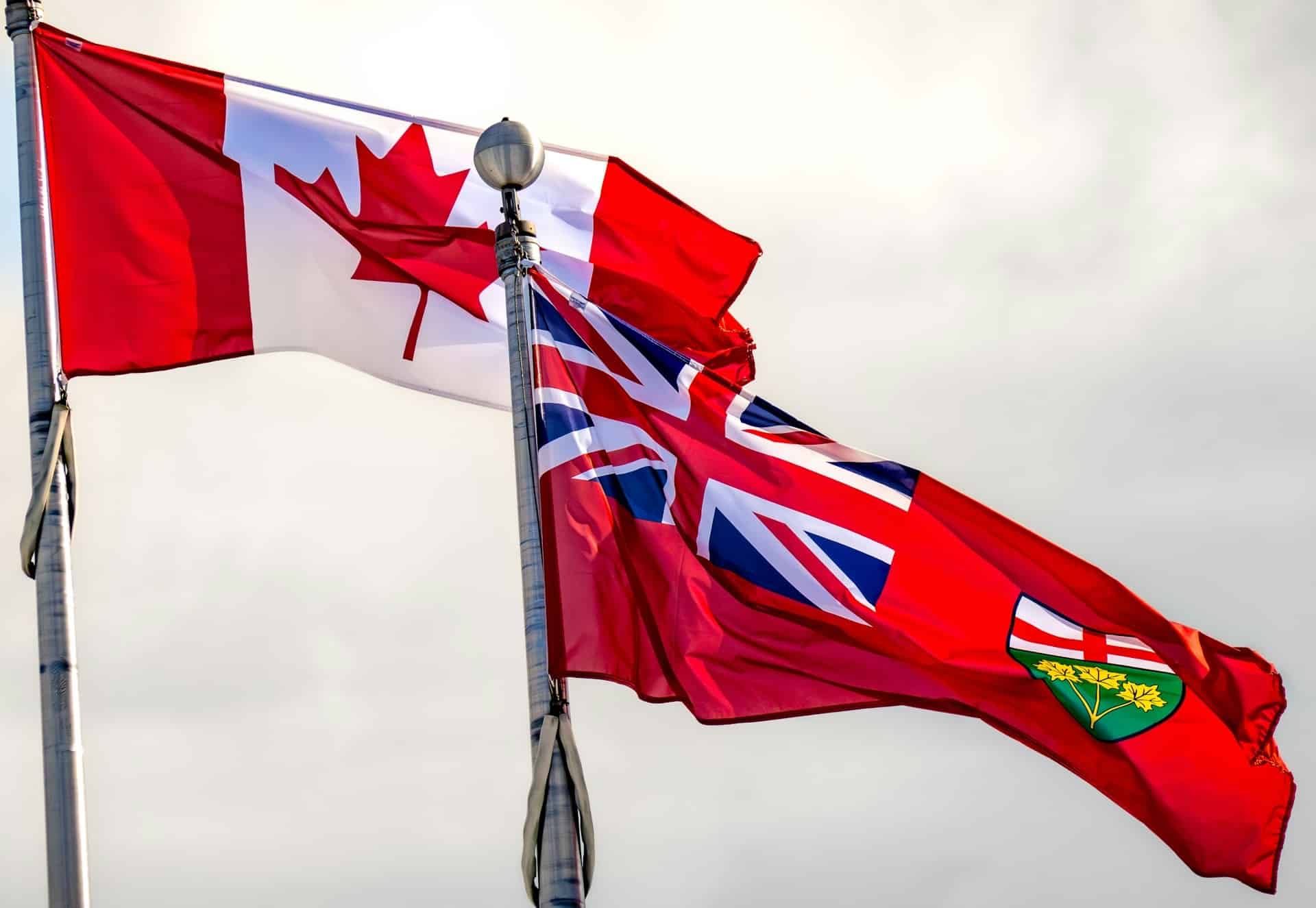The Ontario and Canada flags flying side by side, representing the Protect Ontario Through Free Trade Within Canada Act, 2025
