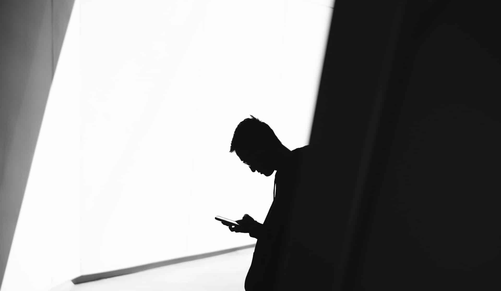 person using cell phone by window