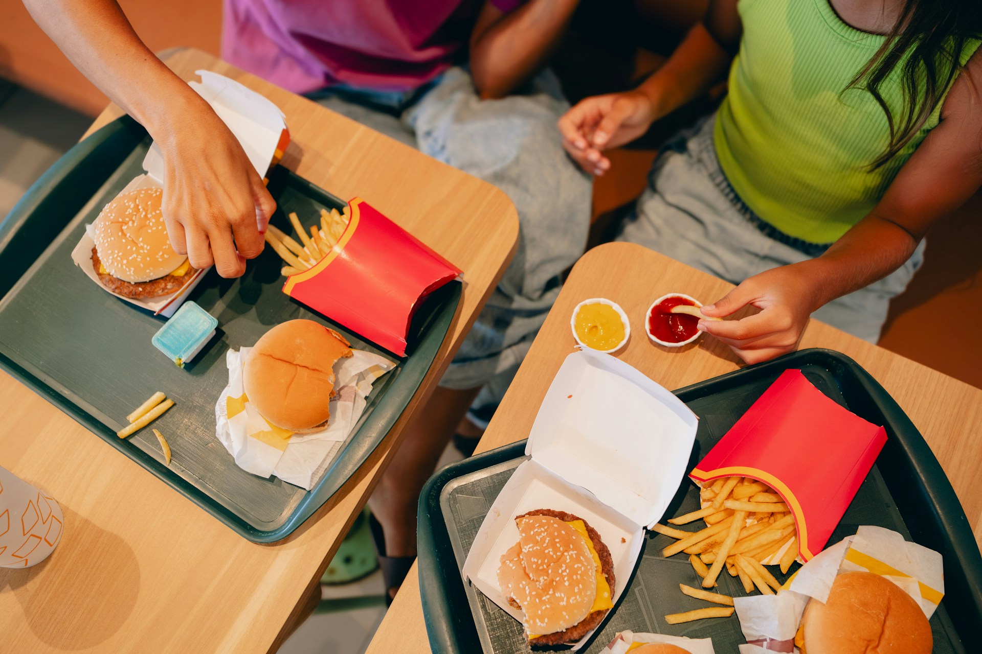 Two people sitting at a table eating fast food representing Ontario foreign worker caps and employer hiring issues.